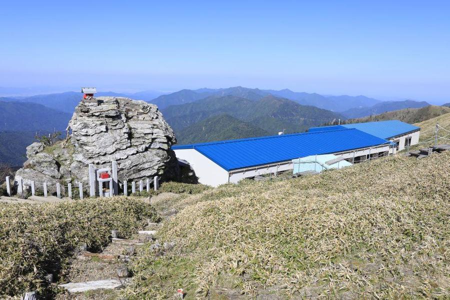 Roof of the Hutte and the sacred boulder(Photo by K.Mizutani)